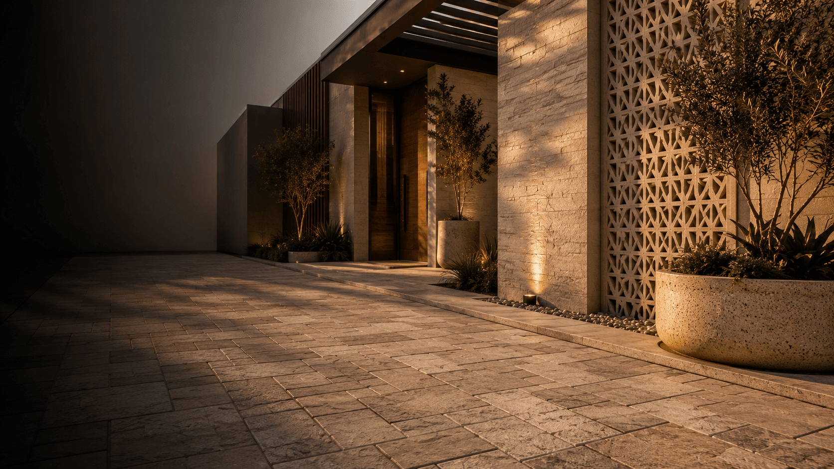 Warm architectural entrance with pavers, planter, wall cladding, and GRC jali